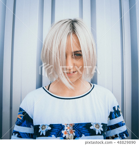 Portrait of cute girl with white short hairstyle. Her hair cover half face. She is looking forward Portrait of cute girl with white short hairstyle. Her hair cover half face. She is looking forward 48829890