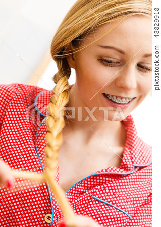 Woman doing braid on blonde hair 48829918
