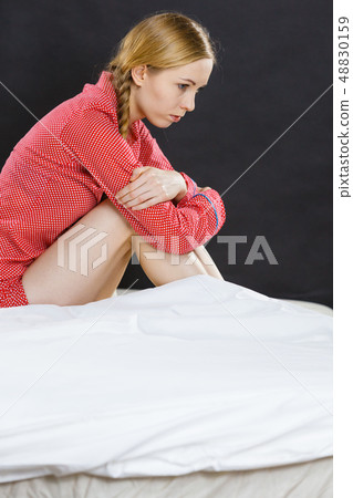 Sad depressed young woman in bed 48830159