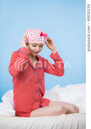 Funny woman wearing pajamas and bathing cap 48830239