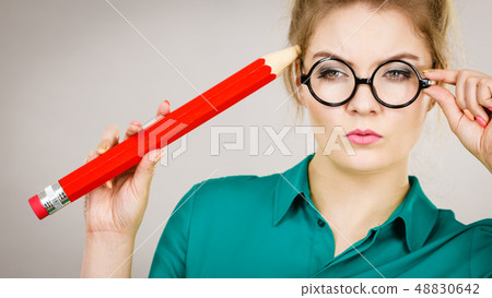 Woman confused thinking, big pencil in hand 48830642