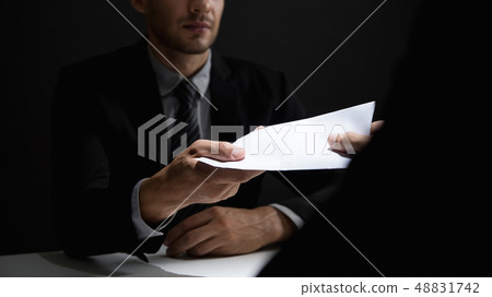 Businessman giving bribe money in the envelope to Businessman giving bribe money in the envelope to 48831742
