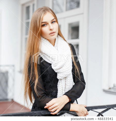 Young beautiful girl with a warm knitted scarf 48833541