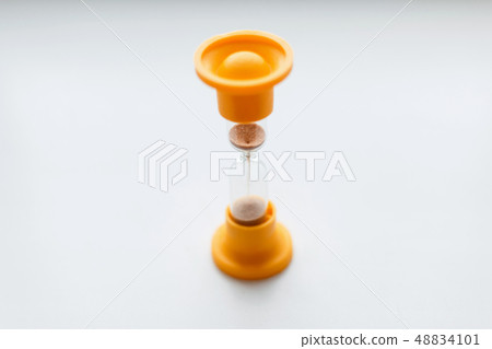 Vintage orange plastic hourglass on a white 48834101
