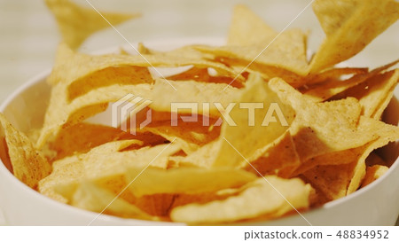 Pouring tortilla chips in a cup, close-up shot 48834952