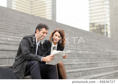 engineers male and female reading article about company in  48836727