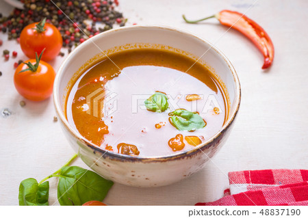 Tomato soup with meat in a white bowl on a white wooden background Tomato soup with meat in a white bowl on a white wooden background 48837190