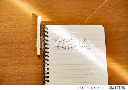 Flat lay, cigarettes and the inscription world no tobacco day written in a notebook, a healthy Flat lay, cigarettes and the inscription world no tobacco day written in a notebook, a healthy 48839168