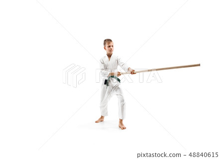 Teen boy fighting with wooden swords at Aikido training in martial arts school Teen boy fighting with wooden swords at Aikido training in martial arts school 48840615