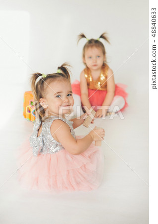 two little girls playing on the floor on a white two little girls playing on the floor on a white 48840633