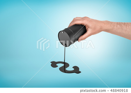 Close-up of man's hand holding oil barrel with thin oil jet trickling down and forming puddle in Close-up of man's hand holding oil barrel with thin oil jet trickling down and forming puddle in 48840918