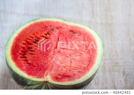 Half a juicy watermelon on a light white wooden 48842481