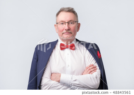 Senior man wearing eyeglasses aand blue suit smiling warmly and confident. 48843561