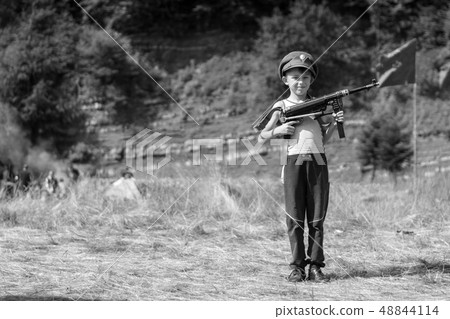 A little boy in his cap holds a trophy weapon MP40 48844114
