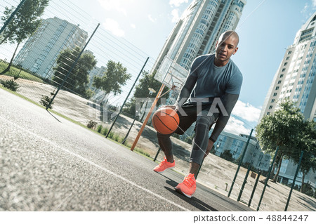 Happy active man playing on the basketball court Happy active man playing on the basketball court 48844247