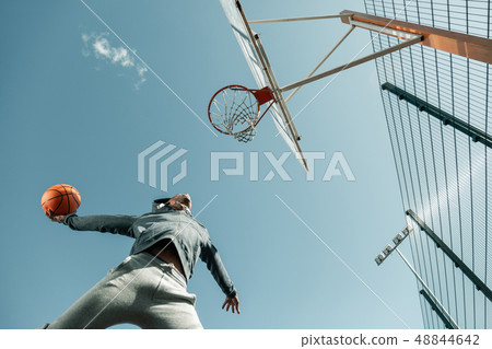 Low angle of a basketball player jumping 48844642