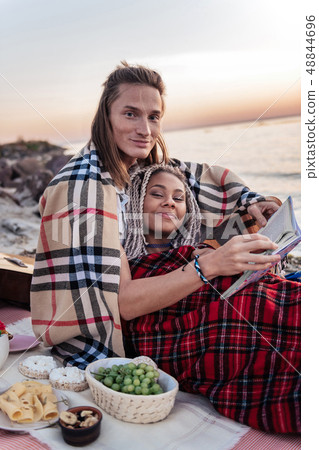 Cute happy couple having romantic dinner with grapes and cheese on beach Cute happy couple having romantic dinner with grapes and cheese on beach 48844696