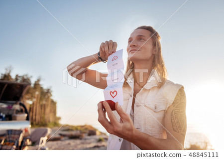 Man with tattoo and long blonde hair presenting his woman proposal ring Man with tattoo and long blonde hair presenting his woman proposal ring 48845111