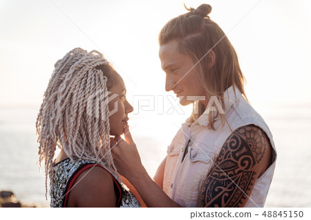 Woman with dreadlocks falling in love with handsome man looking at him Woman with dreadlocks falling in love with handsome man looking at him 48845150