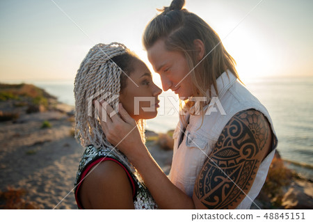 Cute loving couple looking at each other standing near the seaside Cute loving couple looking at each other standing near the seaside 48845151