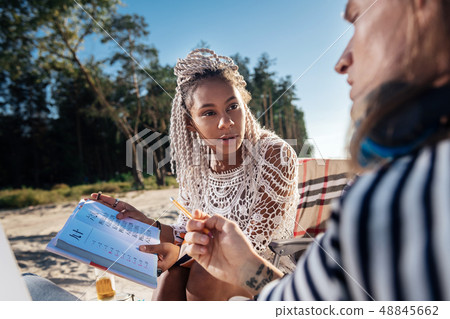 Dark-eyed woman teaching Chinese her boyfriend while resting in nature Dark-eyed woman teaching Chinese her boyfriend while resting in nature 48845662