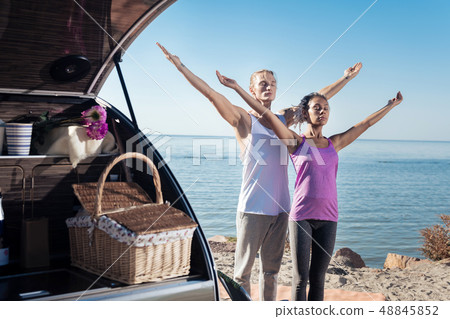 Couple of travelers enjoying eco tourism meditating near their modern trailer 48845852