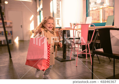Happy blonde girl running with shopping bags Happy blonde girl running with shopping bags 48846367