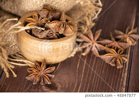Dry brown star anise fruit on brown wood Dry brown star anise fruit on brown wood 48847877