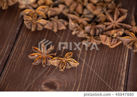 Dry brown star anise fruit on brown wood Dry brown star anise fruit on brown wood 48847880