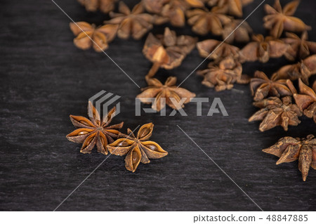 Dry brown star anise fruit on grey stone Dry brown star anise fruit on grey stone 48847885