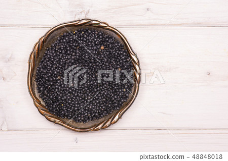Black lentils beluga on grey wood 48848018
