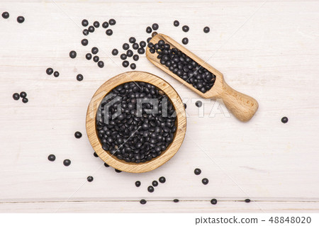 Black lentils beluga on grey wood Black lentils beluga on grey wood 48848020