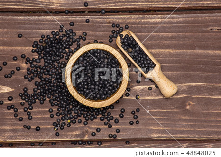 Black lentils beluga on brown wood Black lentils beluga on brown wood 48848025