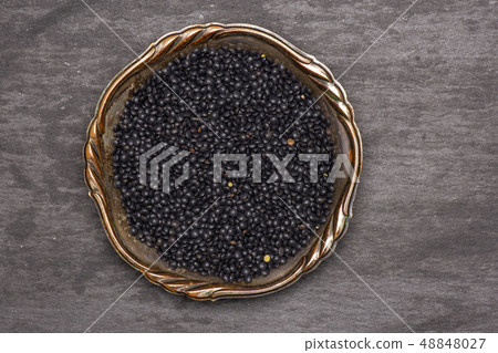 Black lentils beluga on grey stone Black lentils beluga on grey stone 48848027
