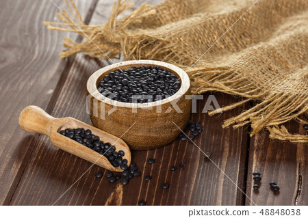Black lentils beluga on brown wood Black lentils beluga on brown wood 48848038