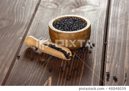 Black lentils beluga on brown wood Black lentils beluga on brown wood 48848039