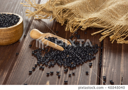 Black lentils beluga on brown wood 48848040