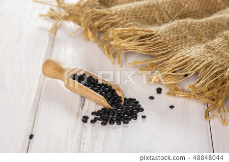 Black lentils beluga on grey wood 48848044