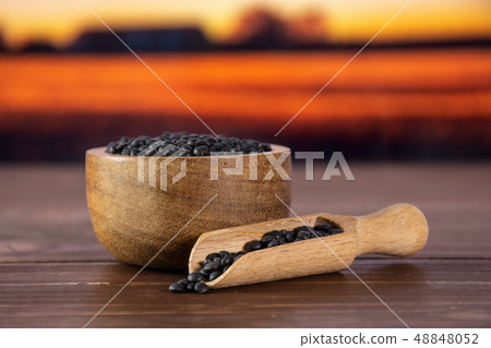 Black lentils beluga with autumn field behind 48848052