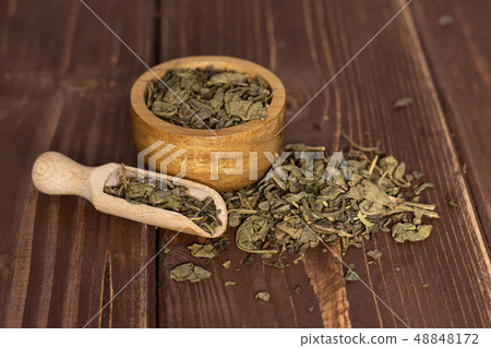 Dry green tea on brown wood 48848172