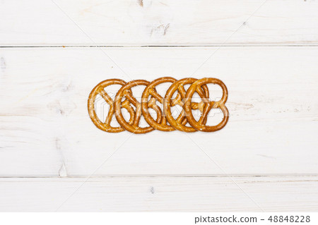 Mini salted pretzels on grey wood Mini salted pretzels on grey wood 48848228