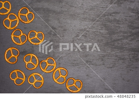 Mini salted pretzels on grey stone Mini salted pretzels on grey stone 48848235