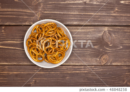 Mini salted pretzels on brown wood Mini salted pretzels on brown wood 48848238