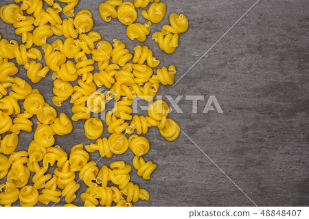 Raw pasta funghetto on grey stone Raw pasta funghetto on grey stone 48848407