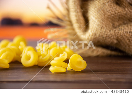 Raw pasta funghetto with autumn field behind 48848410