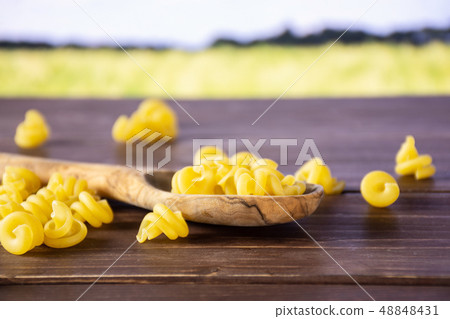 Raw pasta funghetto with field behind 48848431