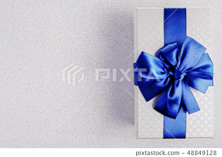 Gift box with blue ribbon on Silver background 48849128