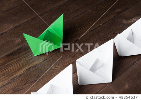 Business leadership concept with white and color paper boats on wooden table Business leadership concept with white and color paper boats on wooden table 48854637