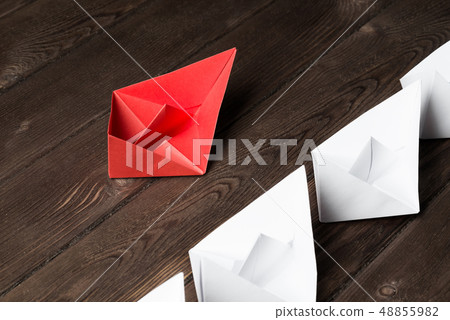 Business leadership concept with white and color paper boats on wooden table 48855982
