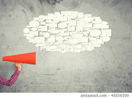 Hand of woman holding red paper trumpet against concrete background 48856500